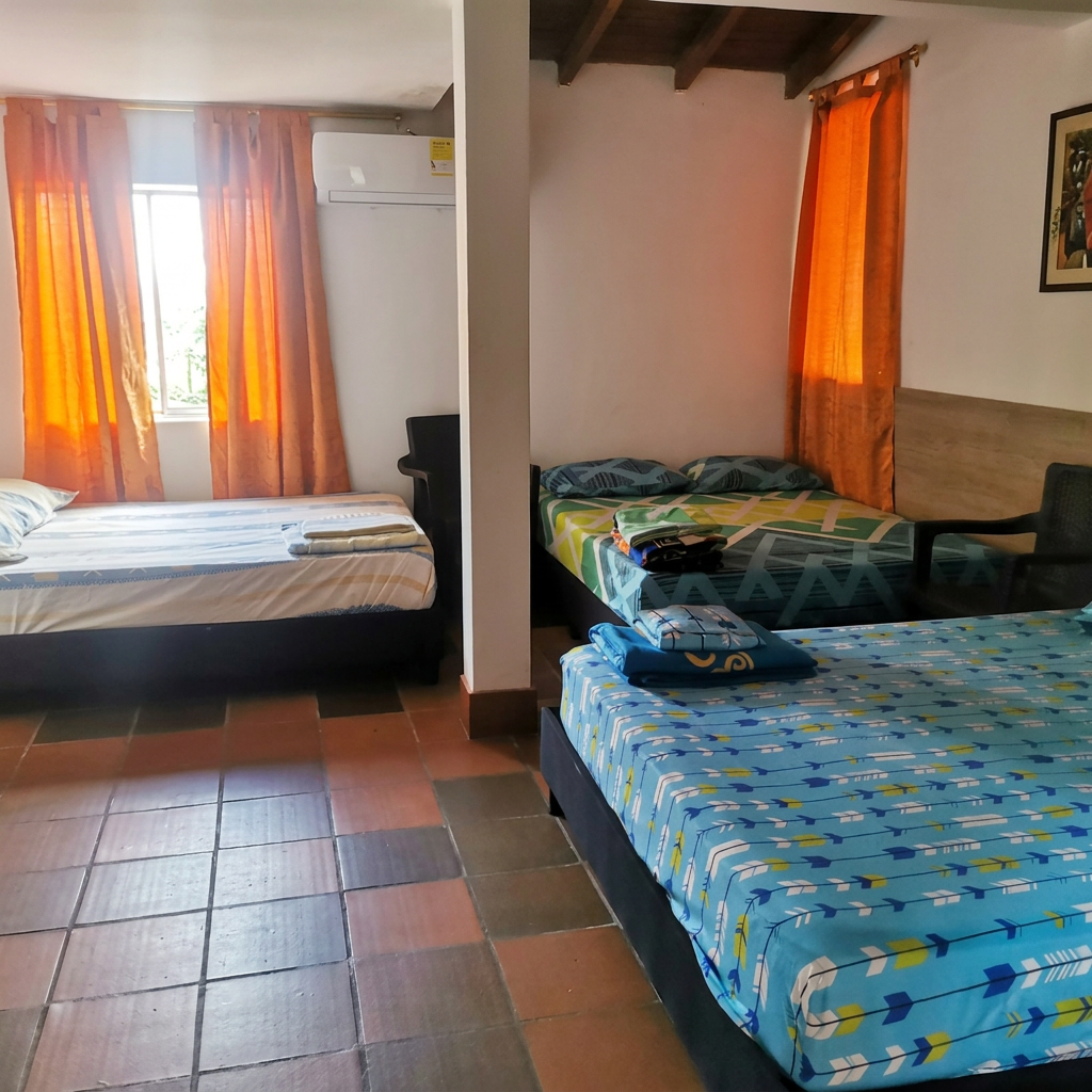Habitación amplia con múltiples camas y aire acondicionado